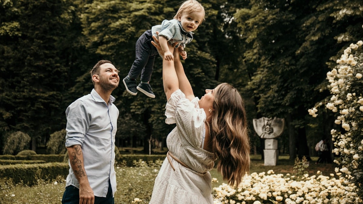 a man holding a little girl up in the air